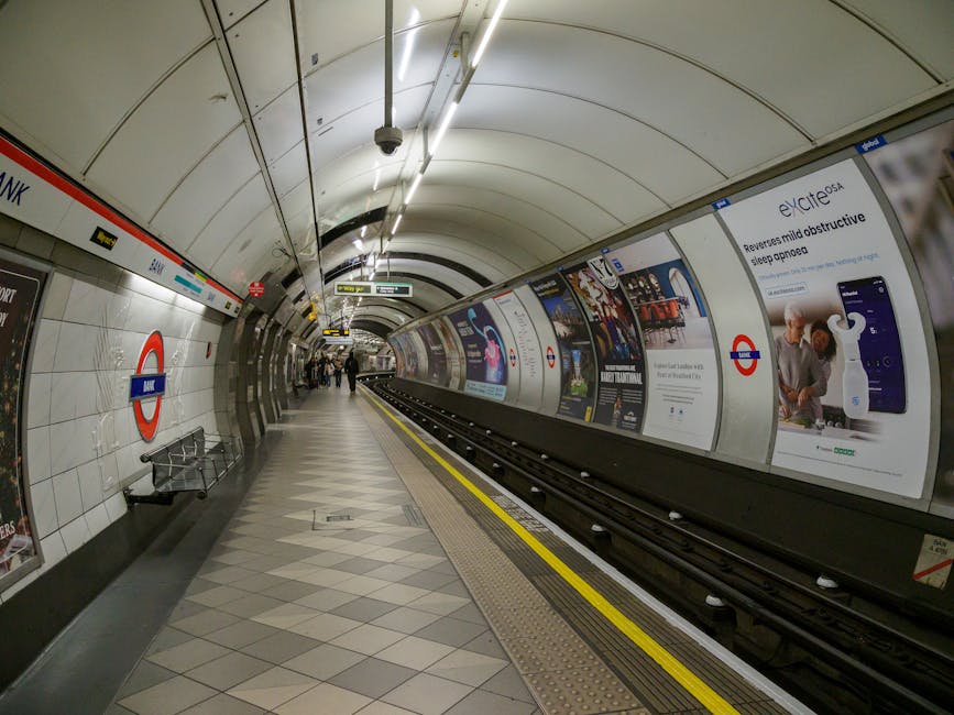 An empty platform at High Barnet tube station featuring white tiled walls with the classic London Underground roundel signage. The platform has a clean, tiled floor with a diamond pattern, and a few p